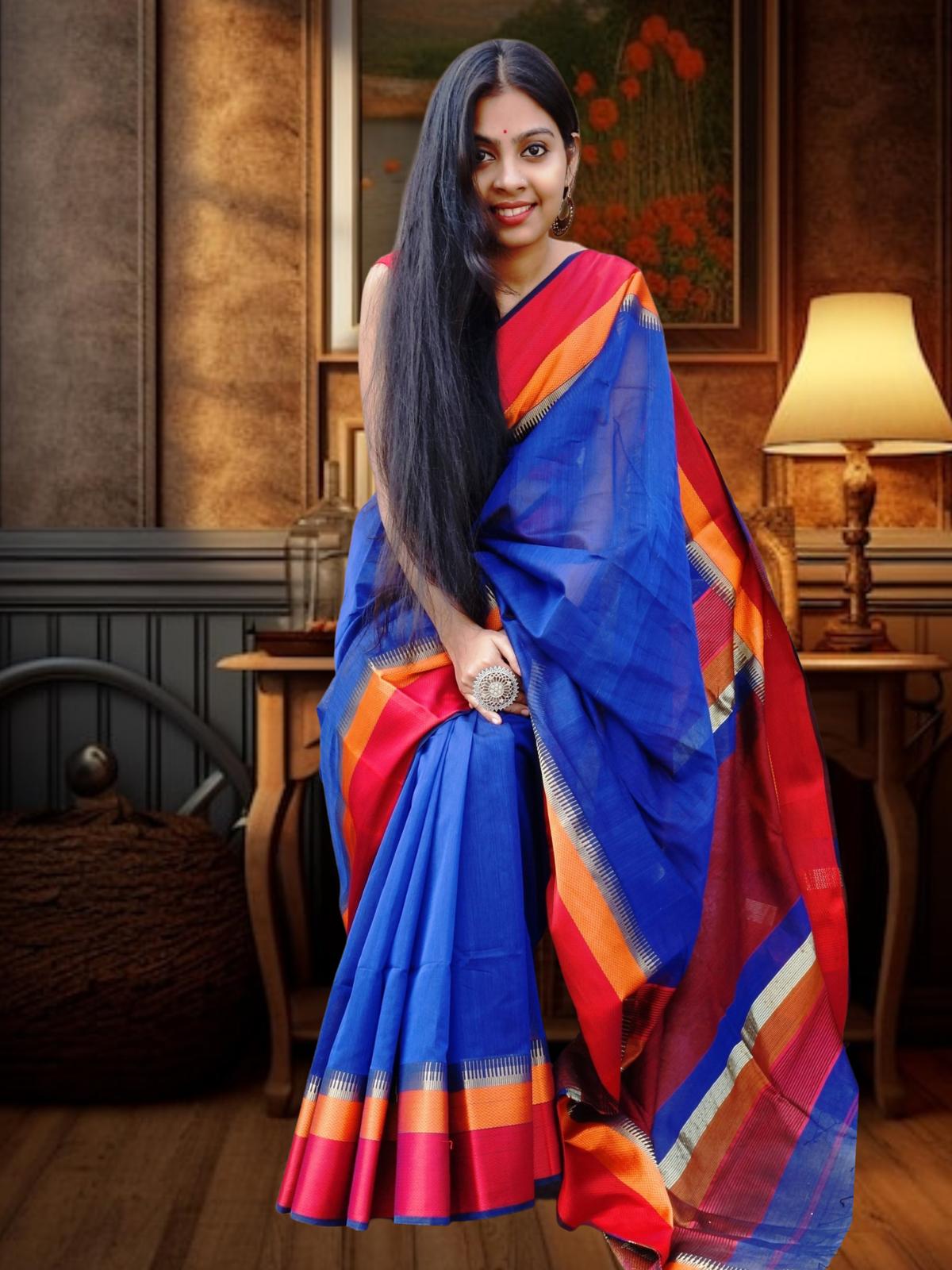 Royal blue Maheshwari silk saree with vibrant red and orange border, worn by a woman indoors