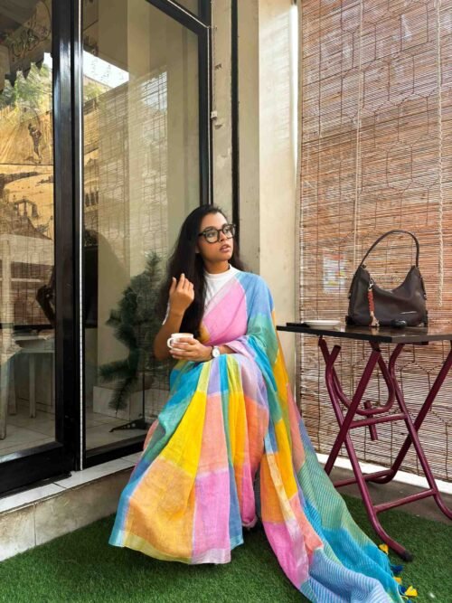 Model wearing Bahaar multicolour cotton linen saree with soft pastel stripes, styled casually in a café setting