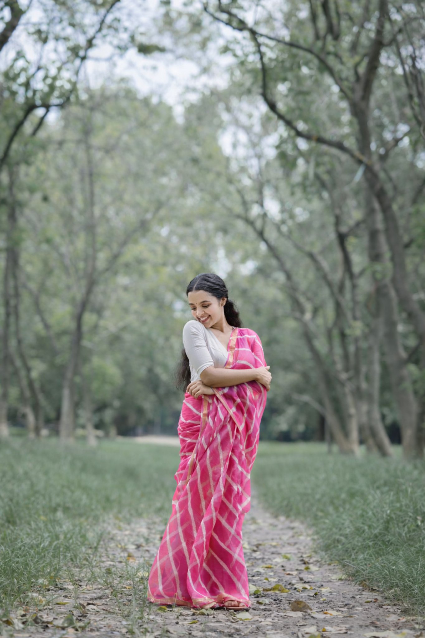 Woman wearing rani pink Kota cotton saree with zari border and diagonal stripes