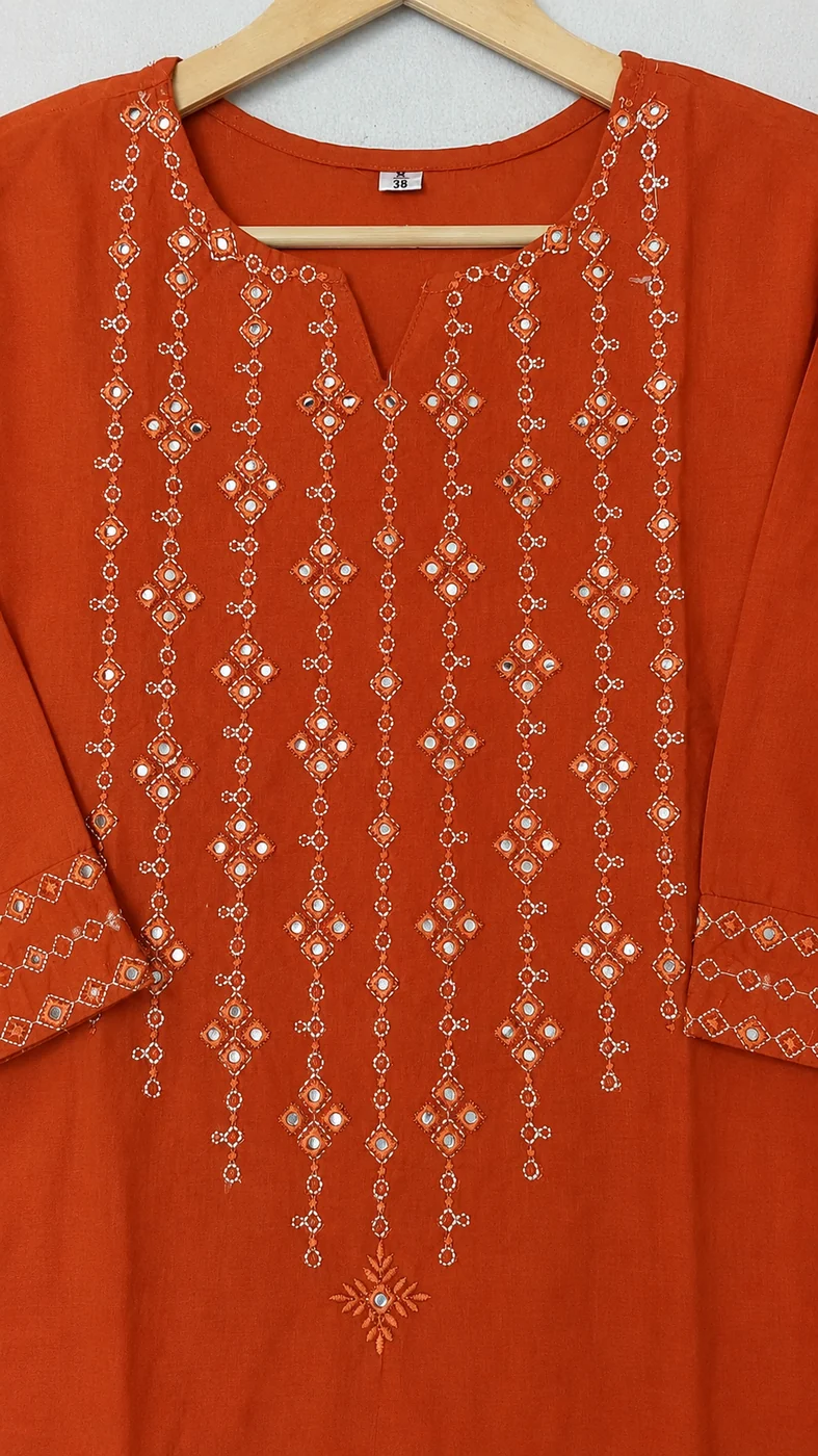 Close-up of mirror work embroidery on rust orange kurta set neckline