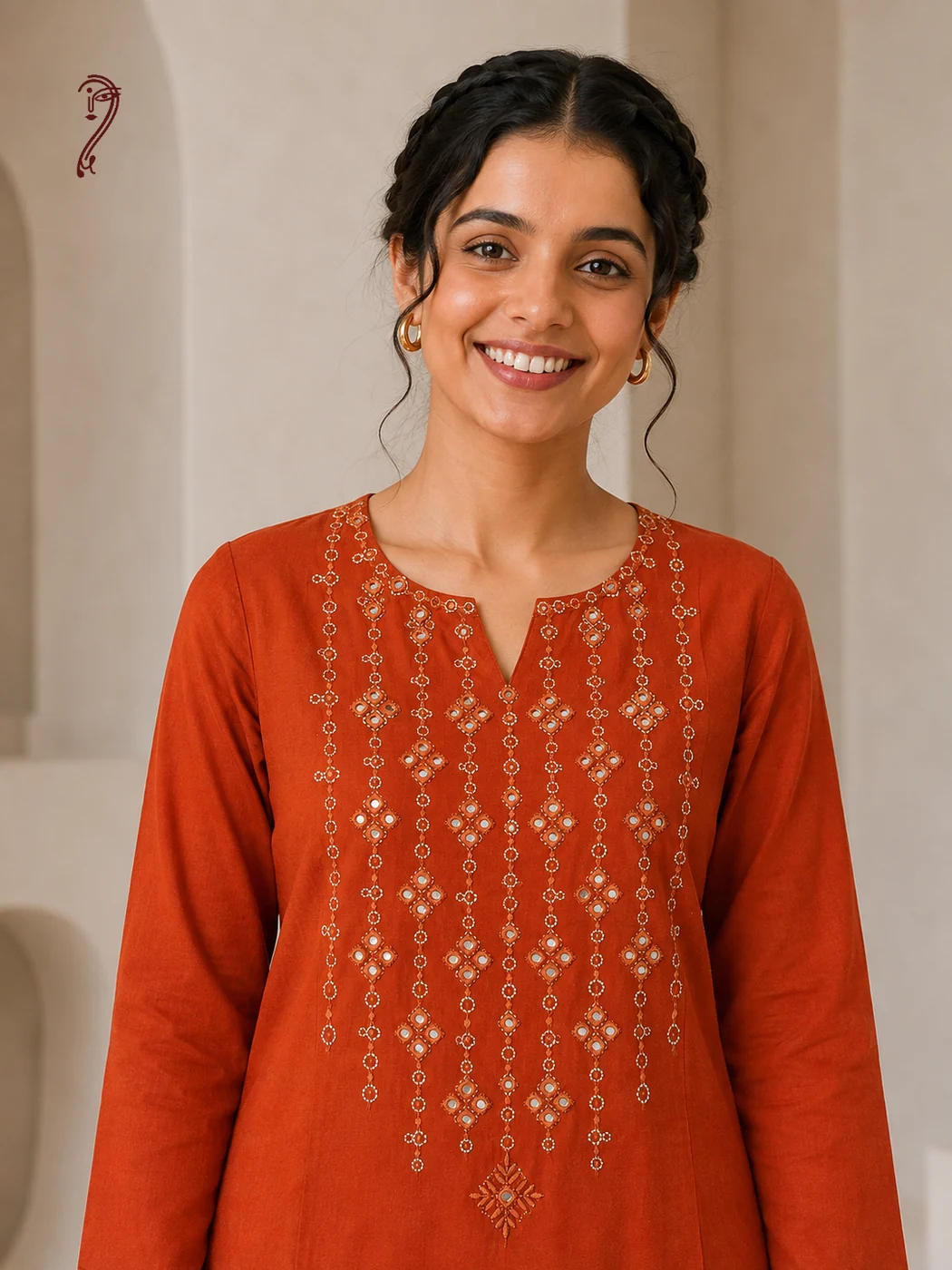 Close-up of mirror and thread embroidery on rust orange cotton kurta